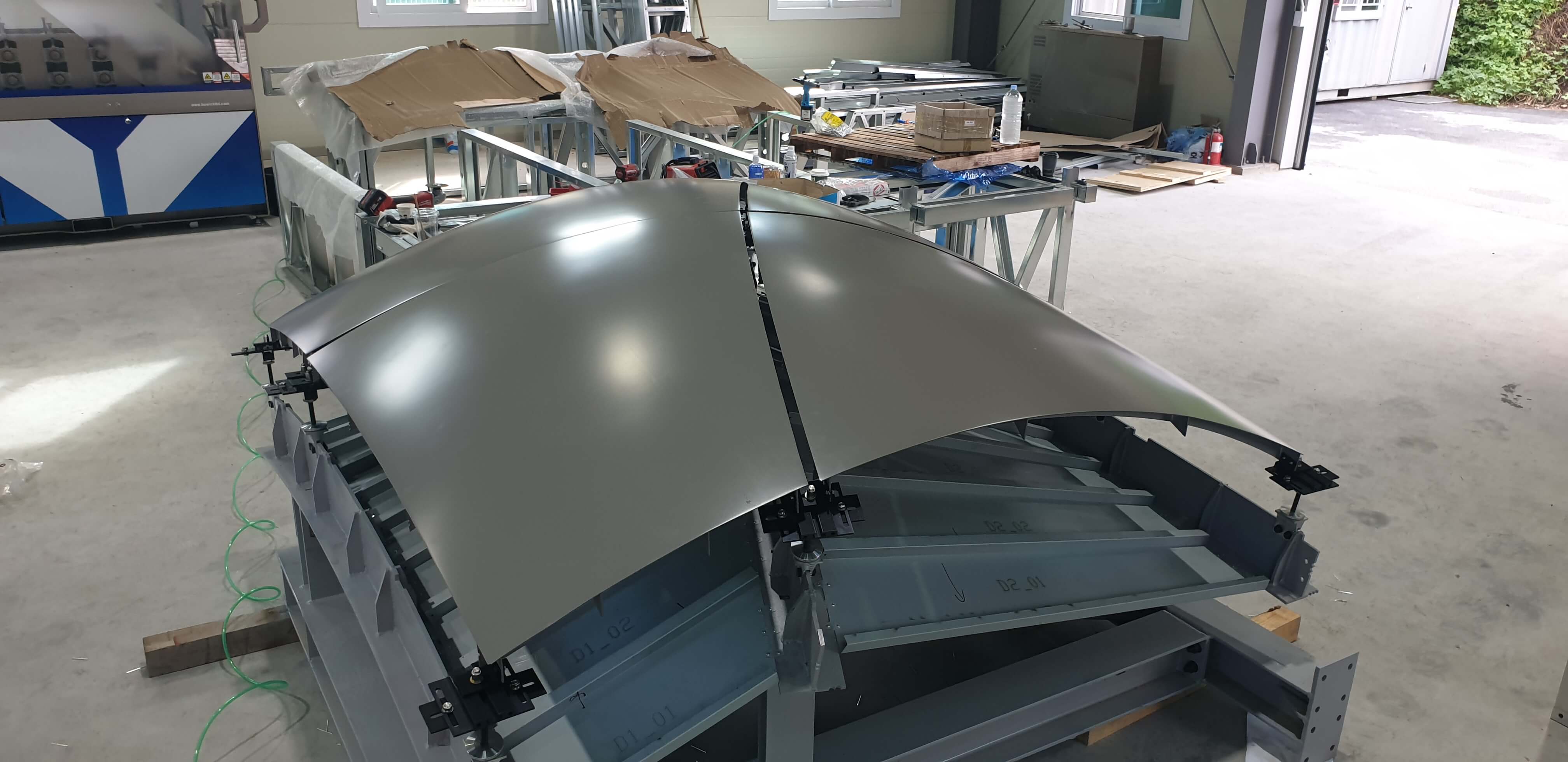Gray curved aluminum panels mounted on a prefabricated steel frame